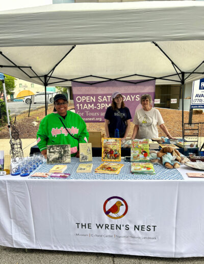 Three ladies at a booth for ”The Wren’s Nest“